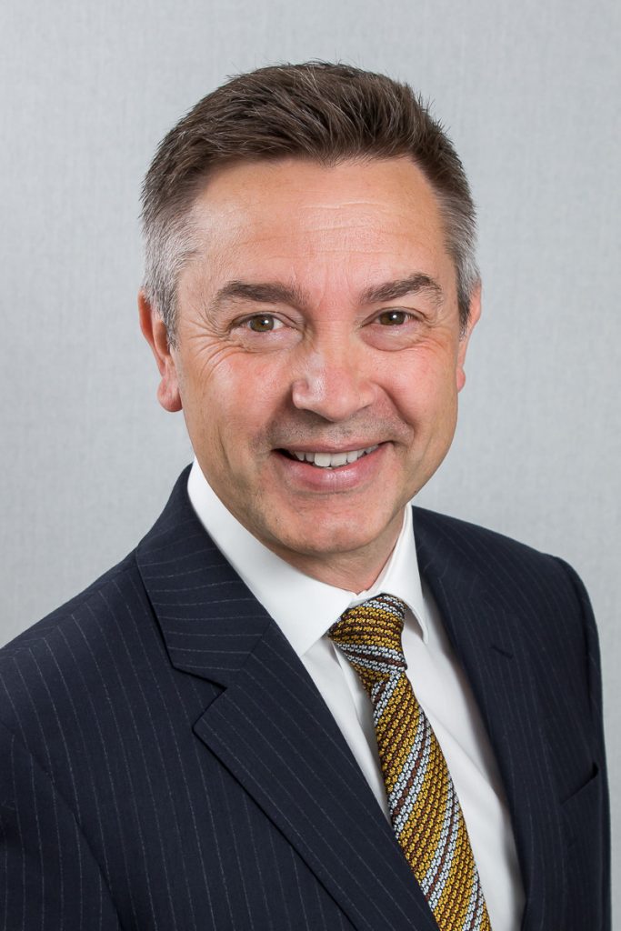 Male headshot against plain backdrop
