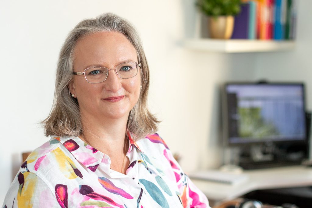 Female headshot showing workplace in background
