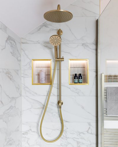 Bathroom photography for The Bromley Bathroom Company_Bickley 33 Portrait photo of brushed brass shower with backlit mosaic tiled niches